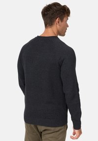 Suéter de punto gris oscuro con mangas largas y cuello redondo. Presenta puños y dobladillo con ribete, mostrando una tela texturizada.