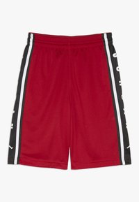 Shorts en mesh rouges avec une taille élastique, panneaux latéraux noirs avec des rayures blanches et du texte, et un design léger.