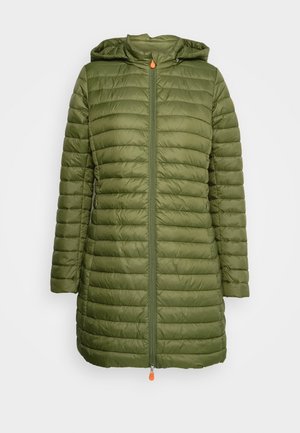 Veste longue matelassée coloris vert olive avec capuche et fermeture éclair frontale ornée de tirettes orange sur un fond blanc.