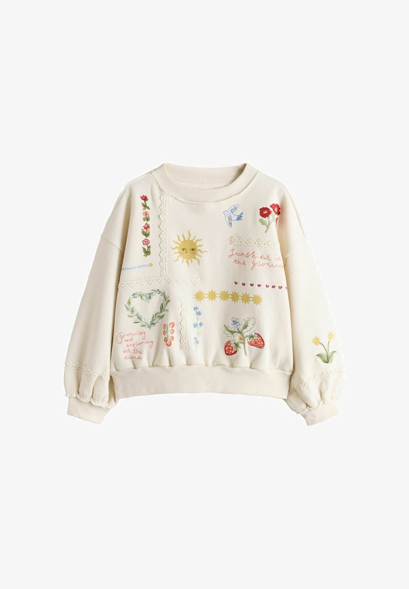 Sweat-shirt crème avec broderies de soleil, fleurs, oiseaux, fraises, et phrases telles que "Lumière du soleil dans la lueur" et "Grandir et explorer tout le temps."