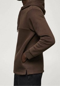 Felpa cappucciata marrone realizzata in tessuto morbido, con tasca frontale a marsupio, zip e aperture laterali per comfort e libertà di movimento.
