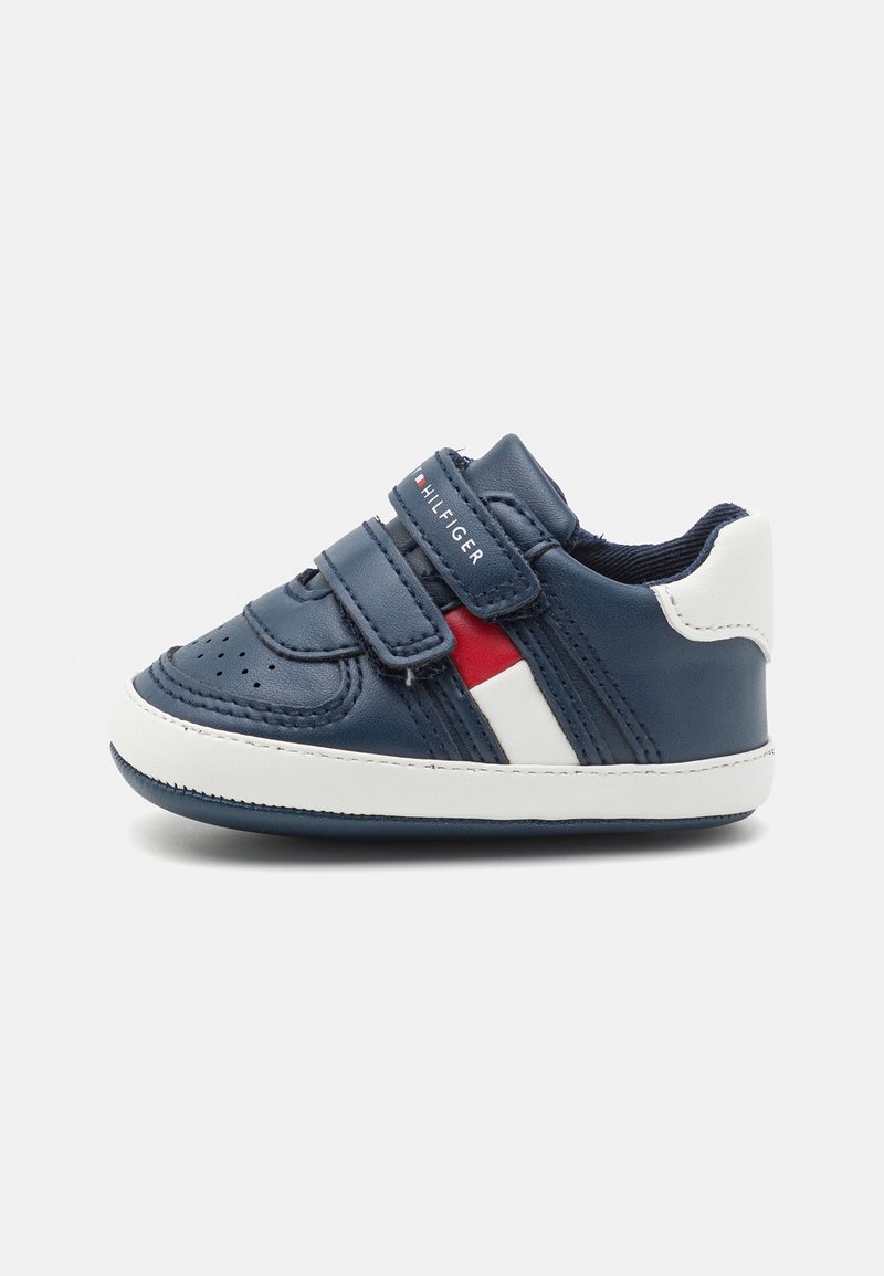 Baskets bleu marine pour tout-petits avec semelle blanche, deux bandes Velcro, et rayures latérales rouges et blanches sur fond uni.