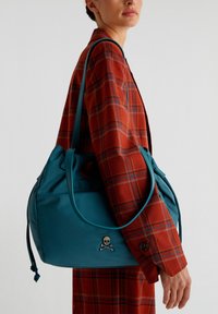 Borsa a tracolla teal realizzata in materiale morbido, con un emblema di teschio e ossa incrociate, dal design morbido e con due lunghe maniglie.