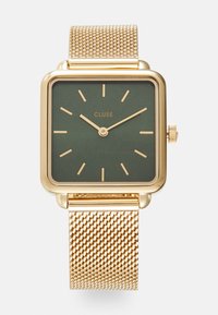 Montre carrée en or avec un cadran vert foncé, index horaires en or et bracelet en maille dorée. Elle dispose d'une couronne sur le côté droit pour les réglages.