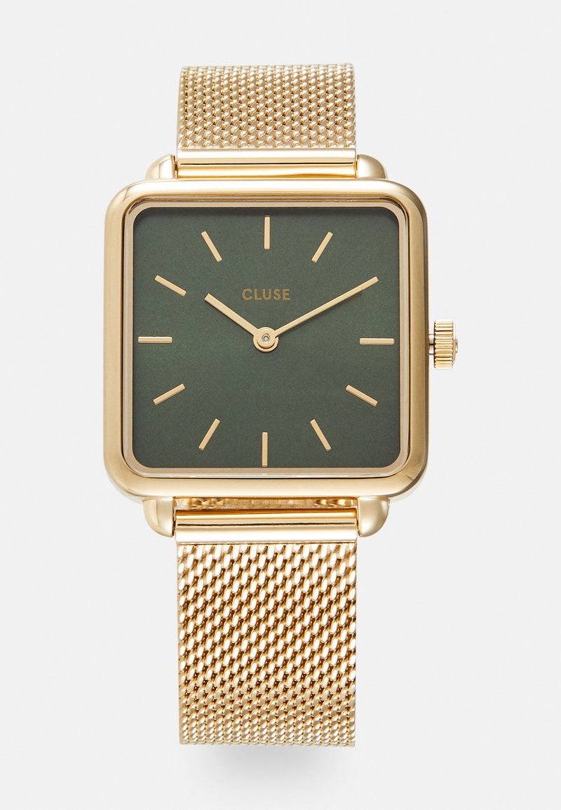 Montre carrée en or avec un cadran vert foncé, index horaires en or et bracelet en maille dorée. Elle dispose d'une couronne sur le côté droit pour les réglages.
