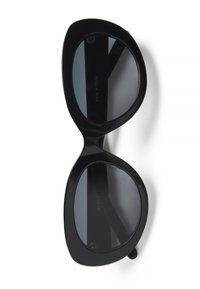Cat-eye solbriller i sort plastic. Runde linser og bredt rammedesign. Mørkt tonede linser med subtil logo detalje på indersiden.