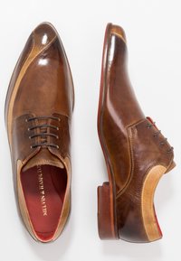 Chaussures habillées en cuir marron au design élégant, avec un accent marron clair, une texture lisse, un bout rond et une fermeture à lacets. Doublure intérieure rouge.