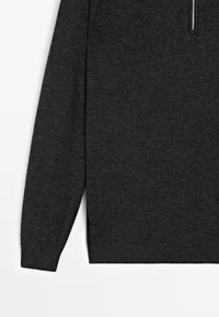 Dunkelgrauer, langärmeliger Strickpullover mit gerippten Bündchen und einem sichtbaren, metallenen Reißverschluss an der oberen rechten Seite.
