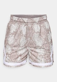 Snake print shorts in beige tones feature an elastic waistband, white side accents, and a textured pattern resembling scales.