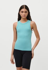 En tettsittende, ermeløs topp i lyseblå ribbet materiale med rund hals, sammen med svarte sykkelshorts. Glatt tekstur og enkelt design.