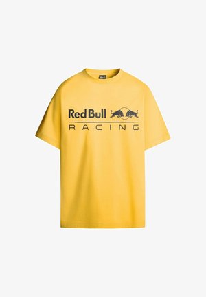 Rumena bombažna majica s kratkimi rokavi, ki ima velik črn logo "Red Bull Racing" in dve črni grafiki bika.