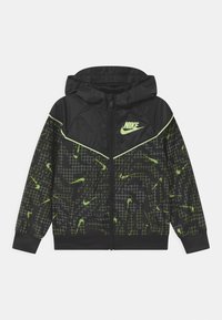 Černá zipová bunda Nike s kapucí, zdoben�á zelenými abstraktními vzory a logem. Vyrobena z lehkého, lesklého materiálu.