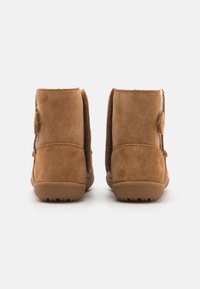 Brune semed botter til ankelen med myk tekstur, rund t�å og flat gummisåle. Har en sideknappdetalj for stil og funksjonalitet.