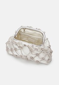 Kleine crèmekleurige satijnen clutch met zilveren frame, open bovenkant en decoratieve beaded netting overlay. Interne zak zichtbaar met merklabel.