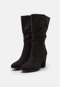 Stivali alla caviglia in suede nero con un design arricciato, punta a punta e tacco a blocco. Texture liscia e stile semplice senza decorazioni.