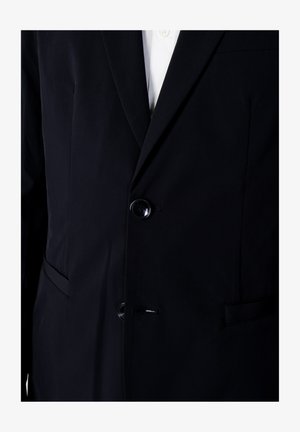 Blazer navy con tessuto testurizzato, chiusura a un bottone e due tasche frontali. Le alette affilate aggiungono al suo design su misura.