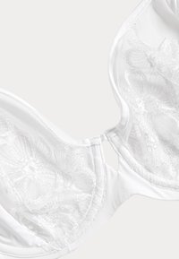 Hvid bh med blomster- og blonde detaljer, gennemsigtige mesh-kopper og en glat stofkant. Underwire-struktur med justerbare stropper.