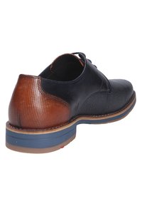 Kožená bota s černým síťovaným svrškem, hnědým detailem na patě a kontrastní modrou podrážkou. Texturované plochy dodávají vizuální zajímavost.