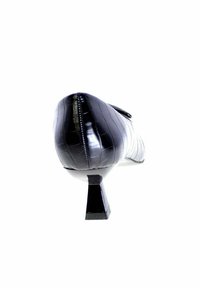 Scarpa con tacco alto in pelle verniciata nera con un motivo in pelle di coccodrillo testurizzato, caratterizzata da un tacco quadrato e un design elegante e fluido.