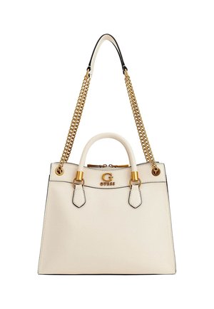 Sac à main en cuir couleur crème avec bandoulière chaîne dorée, poignées supérieures et logo de la marque GUESS en doré sur le devant.
