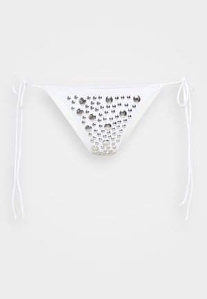 Balta bikini kelnaitė su sidabro metaliniais studais, išdėstytais raštu. Su rišamais šonais ir trikampio forma. Lygus paviršius.