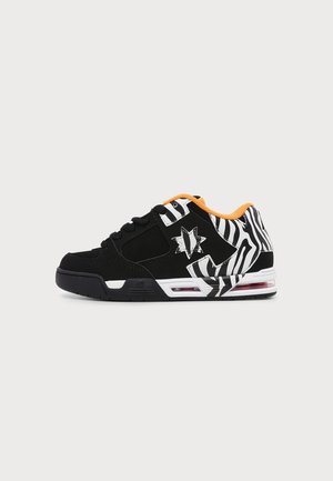 Zwart-witte sneaker met zebraprint, sterlogo, oranje binnvoering en zichtbare aircushionzool, zijaanzicht op egale achtergrond.