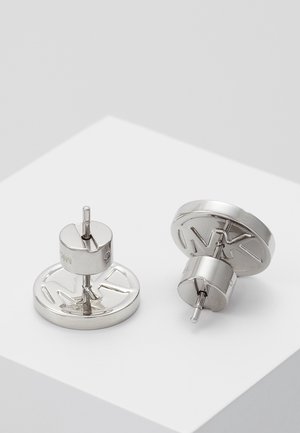 Round silver stud earrings with engraved MK logo, displayed on a white surface.