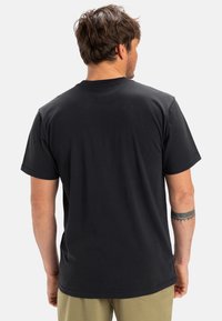 Černé bavlněné tričko s krátkými rukávy, klasickým kulatým výstřihem a jemnou texturou. Disponuje minimalistickým designem a volným střihem.