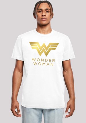 Valkoinen puuvillapaita, jossa on suuri kultainen "Wonder Woman" -logo siipikoristeilla. Säännöllinen istuvuus, lyhyet hihat ja pyöreä kaula-aukko.