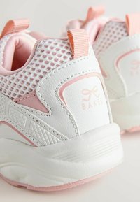 Sneakers per bambini piccoli bianchi e rosa chiaro con tessuto in mesh, linguette per tirare e suole spesse, con logo del marchio sul pannello del tallone.
