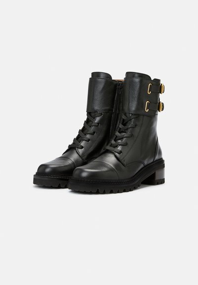 Black leather ankle boots with a lace-up front, gold-accented buckles, zip closure, and a rugged sole with a low heel.