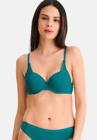 Teal push-up BH met kantafwerking, gladde cups en verstelbare bandjes. Gecombineerd met bijpassende teal slipjes. Zachte stof met een matte afwerking.