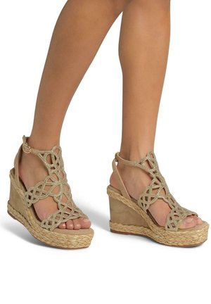 Beige wedge sandals featuring a braided jute sole, delicate woven straps, and a decorative design with metallic accents.