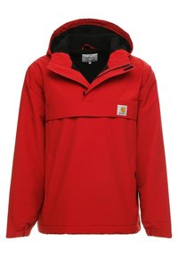 Red waterproof anorak jacket with a front pocket, adjustable hood, and black fleece lining. Features a Carhartt logo patch.