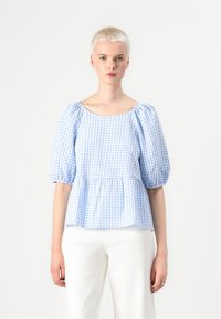 Bluse med blå og hvit rutete mønster, pufferm og peplum-bunn. Lett stoff med rund hals og rynkede detaljer.