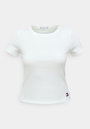 T-shirt blanc en coton à manches courtes avec un col rond et une texture côtelée. Petit logo en bas à gauche.