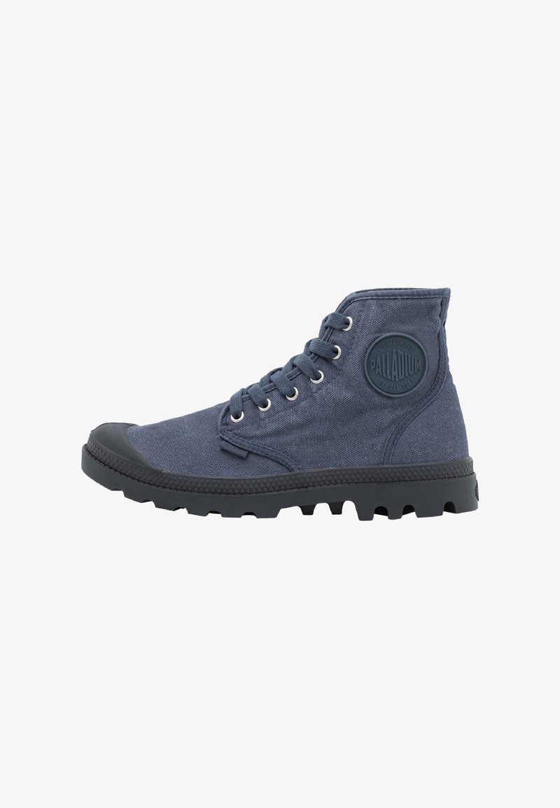 Botte montante en toile bleu marine avec semelle et embout en caoutchouc noir, fermeture à lacets à l’avant et patch rond avec logo sur la cheville.