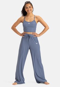 Top corto azul de canalé con tirantes finos y pantalones holgados a juego con cordón ajustable, elaborados con una tela suave y transpirable.