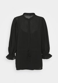 Chemise noire en tissu texturé et transparent, avec de longues manches bouffantes à poignets volantés et une fermeture à nouer à la taille. Encolure arrondie.