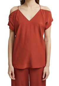 Top rojo de cuello en V con mangas cortas y diseño de hombros descubiertos. Textura suave, corte relajado y detalles de costura mínimos.
