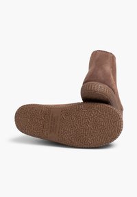 Stivali alla caviglia in suede marrone con suola in gomma testurizzata caratterizzata da una presa a motivo e un tacco leggero. Design pulito, estetica minimalista.