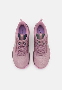 Baskets de sport roses avec un dessus en mesh, un laçage renforcé et une finition texturée. Présente des accents vert foncé et une semelle extérieure noire.