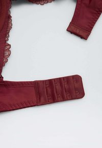Sostenedor de encaje burdeos con un tejido suave. Presenta un cierre de gancho y ojo con múltiples ajustes y un elegante borde de encaje decorativo.