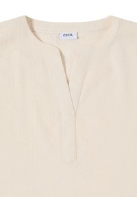 Bluse mit cremefarbener Textur, rundem Ausschnitt und V-förmigem vorderem Schlitz, mit "CECIL" Markenetikett innen am Kragen.