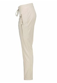 Beige zúžené kalhoty s postranní kapsou na zip a stahovací šňůrkou v pase, zobrazené z pravé strany.