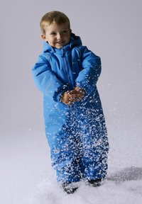 Blue insulated snowsuit with a hood, elastic cuffs, and zip closure. Child stands in snow, hands outstretched, with snowflakes around.