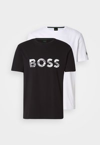 Zwei T-Shirts: eines schwarz mit einem weißen Gittermuster-"BOSS"-Logo und eines ganz in Weiß. Beide haben kurze Ärmel und einen Rundhalsausschnitt.