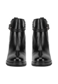 Fekete bőr bokacsizma elegáns dizájnnal, kerek orral és oldalsó hevederrel, csattal. Fényes textúra és minimalista stílus.
