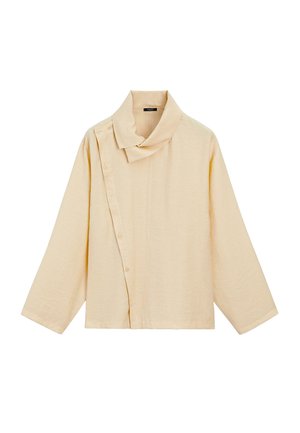 Beige top met lange mouwen en asymmetrische knoopsluiting en brede kraag, gemaakt van gestructureerde stof.