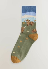 Zelené pančuchy po kolená s modrým lemom, ozdobené hnedými kravičkami a kvetmi. Špička a päta majú horčicovo žltú farbu a rebrovanú textúru.